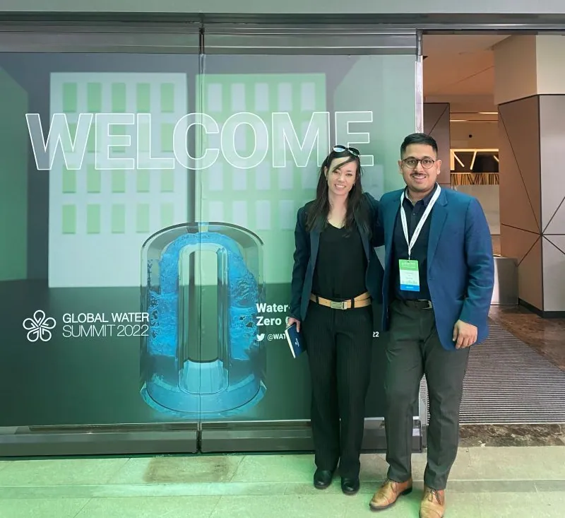 Two Pani team members in front of a Global Water Summit 2022 welcome sign in Madrid