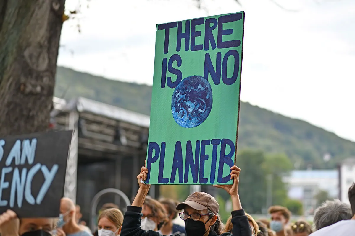 Climate action protester holds sign saying "There is no planet B"